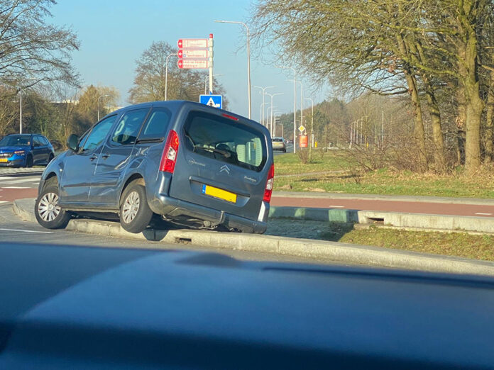 Auto hangt op trottoirband bij Lidl Rotonde Reeshof